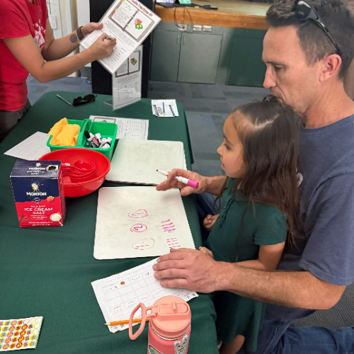 A parent working his child on a math activity